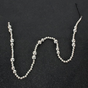 Detail shot of silver bead hair chain with multi-size polished metallic spheres on black