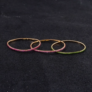 Macro detail of three-piece set elastic bracelets with rose red and green rhinestones