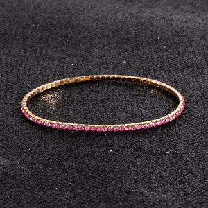 Close-up of pink rhinestones in gold setting on a sparkling elastic tennis bracelet