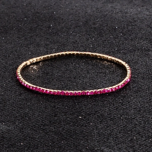 Macro shot of rose gold elastic bracelet with sparkling round pink rhinestones