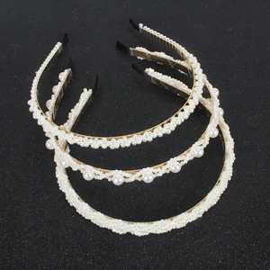 Drei elegante Perlen-Haarreifen aus Goldmetall mit verschiedenen Designs auf dunklem Grund