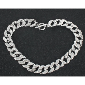 Detail van zilveren Cubaanse schakelketting met micro-pave kristallen in hartvorm