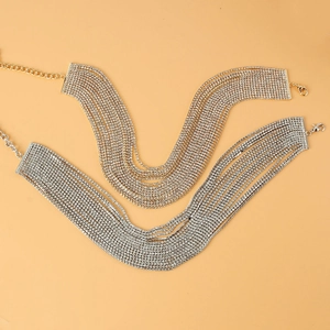 Détail de colliers choker multi-rangs en strass dorés et argentés avec fermoir mousqueton réglable