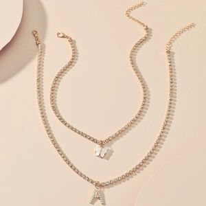 Double-layered gold tennis necklaces featuring a mother-of-pearl butterfly and letter A pendant