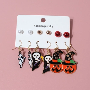Halloween earring set with pumpkin, ghost, and death charms on a pink background
