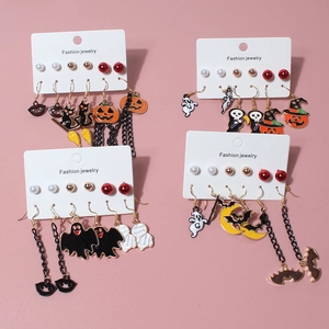 Halloween multi-pair earring set featuring pumpkin ghost and black cat charms on pink background