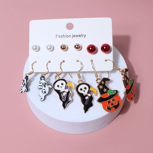 Detailed Halloween earring set with ghost, pumpkin, and reaper charms on pink display