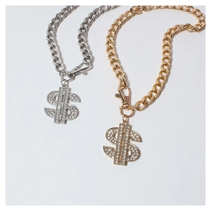Detail of hip hop gold dog chain with rhinestone dollar sign pendant on white background