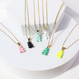 Colorful resin gummy bear pendant necklaces with fine gold chains on display stands