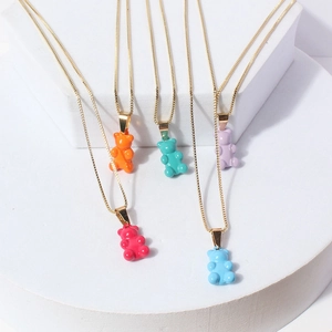 Colorful resin gummy bear pendant necklaces with fine gold chain displayed on white stands