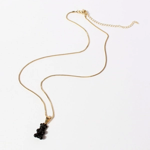 Detail of golden box chain and translucent black bear pendant with lobster clasp