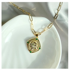 Collier médaillon chic plaqué or avec accents d'émeraude et cristaux étincelants