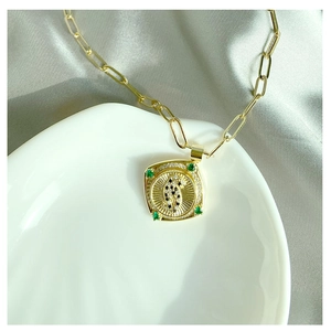 Vue détaillée du collier chaîne trombone doré avec un pendentif dollar serti de pierres