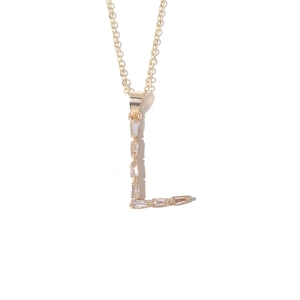 Detailed macro view of gold-plated letter L pendant necklace with baguette-cut zircon