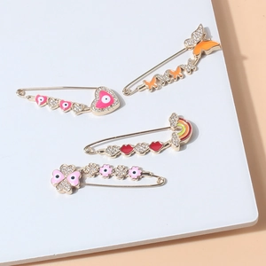 Detail of four-piece gold alloy pins with enamel heart, butterfly, and rhinestones
