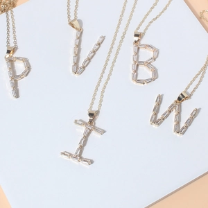 Detail view of gold-plated necklaces with baguette zircon initial letters P, V, B, I, W
