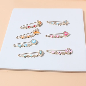 Set of seven gold alloy pins with enamel evil eye, heart, and butterfly crystal details