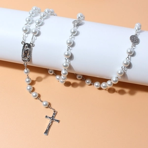 Detail of white pearl rosary beads with silver crucifix and Virgin Mary medal charm