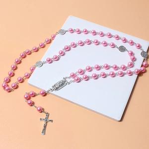 Pink pearl rosary necklace with silver crucifix and religious medals on white base