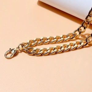 Macro shot of gold Cuban link chain with a decorative heart-shaped lobster clasp detail
