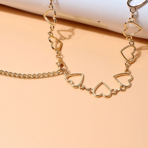 Detail of gold metal belt with hollow heart-shaped links and adjustable lobster clasp