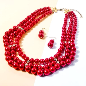 Detail of red multi-layer pearl necklace with gold diamond spacers and matching earrings