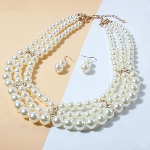 Detail of multi-layer pearl necklace and earrings set with gold metal spacers and crystals