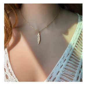 Elegante collana con ciondolo a foglia dorata e texture a piuma su catena sottile