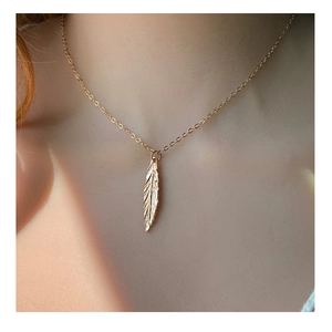 Collana con ciondolo a foglia piuma dorata minimalista con texture realistiche e catena fine