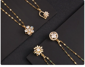 Close-up of four rotating gold pendants with sparkling zircons in floral and heart designs