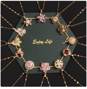 Detailed shot of assorted gold necklaces with zircon clover and heart pendants on black