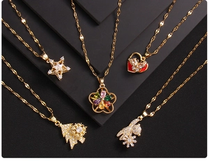 Close-up of five assorted gold-plated necklaces with zircon pendants on black blocks