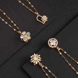 Luxury gold spinning necklaces with sparkling zircon pendants on a black leather background