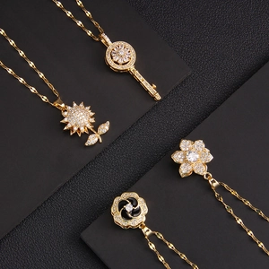 Rotating gold necklaces with micro-pave cubic zirconia pendants on black leather background