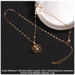Close-up of golden four-leaf clover necklace with colorful zircon and flat sequin chain