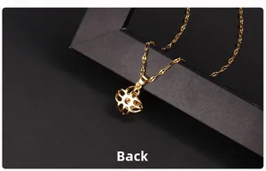 Polished gold clover necklace back view with thin link chain on dark background