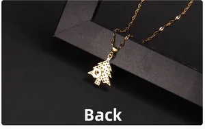 Close-up of golden Christmas tree projection necklace with micro-lens on dark texture
