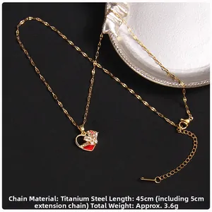 Detail of gold titanium steel necklace featuring a red enamel heart and zircon clover
