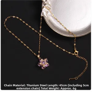 Detail of purple flower pendant necklace with cubic zirconia and gold titanium chain