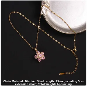 Macro detail of rotating four-leaf clover necklace with purple zircon and gold titanium chain