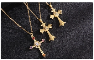 Detail of gold cross necklaces with colorful zircon stones and metallic textures