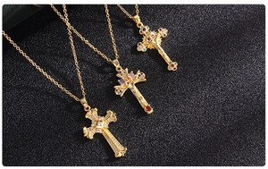 Close-up of three vintage gold crucifix pendants with multicolor cubic zirconia gems