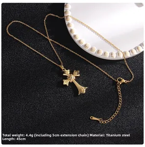 Detailed close-up of a gold-plated titanium steel cross necklace with micro-zirconia stones