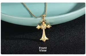 Front view of gold plated cross pendant with pavé zircon stones on ceramic tray