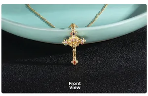 Macro detail of golden crucifix pendant with colorful zircon stones on a ceramic tray