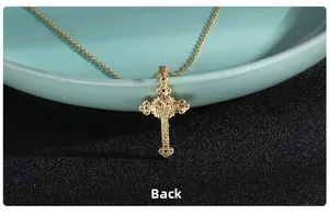 Back view of gold cross pendant with micro-paved gems on elegant ceramic tray
