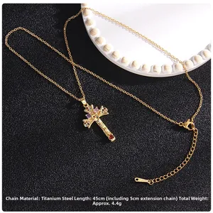 Detailed view of gold cross pendant with colorful zircon stones on titanium steel chain