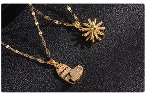 Detailed close-up of gold-plated starburst and heart pendants with pavé zircon stones