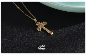 Side view of golden cross necklace showing multi-colored stones and relief details