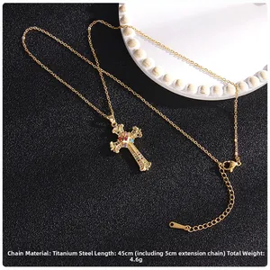 Detail of gold cross pendant with colorful zircon stones on titanium steel chain